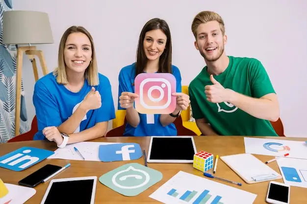 Jóvenes influencers sonríen mientras muestran logos de redes sociales como Instagram, Facebook y WhatsApp en una reunión de estrategia digital