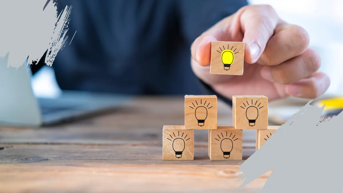 Hand placing a wooden block with a yellow light bulb on top of others, symbolizing innovation and brand differentiation.