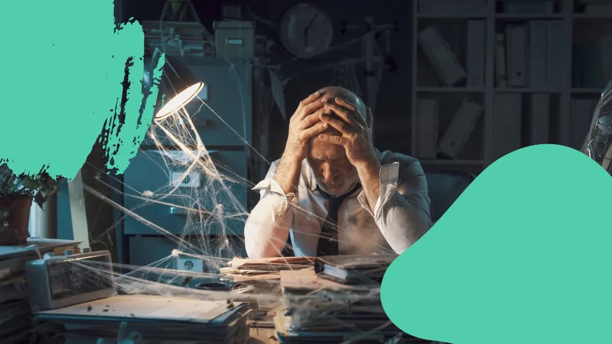 Frustrated man sitting at a desk surrounded by cobwebs, symbolizing outdated communication strategies and crisis mismanagement.