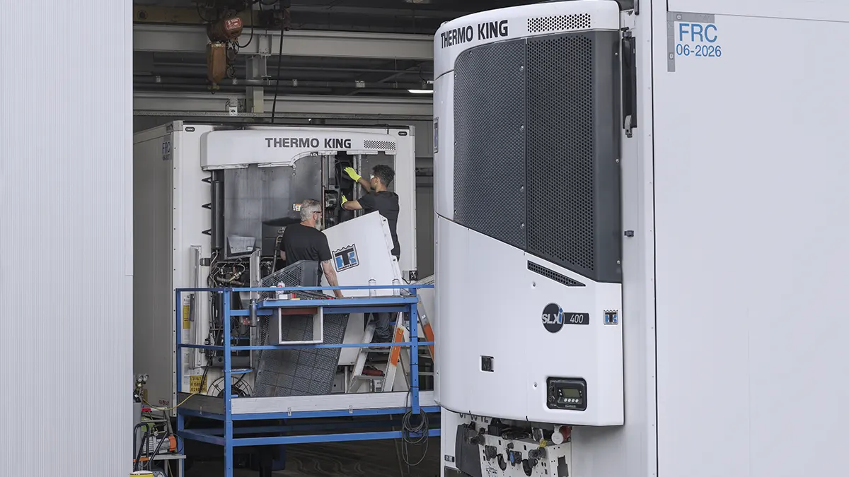 Técnicos trabajando en un equipo de refrigeración Thermo King en un centro de entrenamiento especializado.