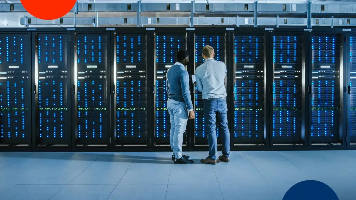 Dos ingenieros revisan los servidores en un moderno centro de datos con luces azules