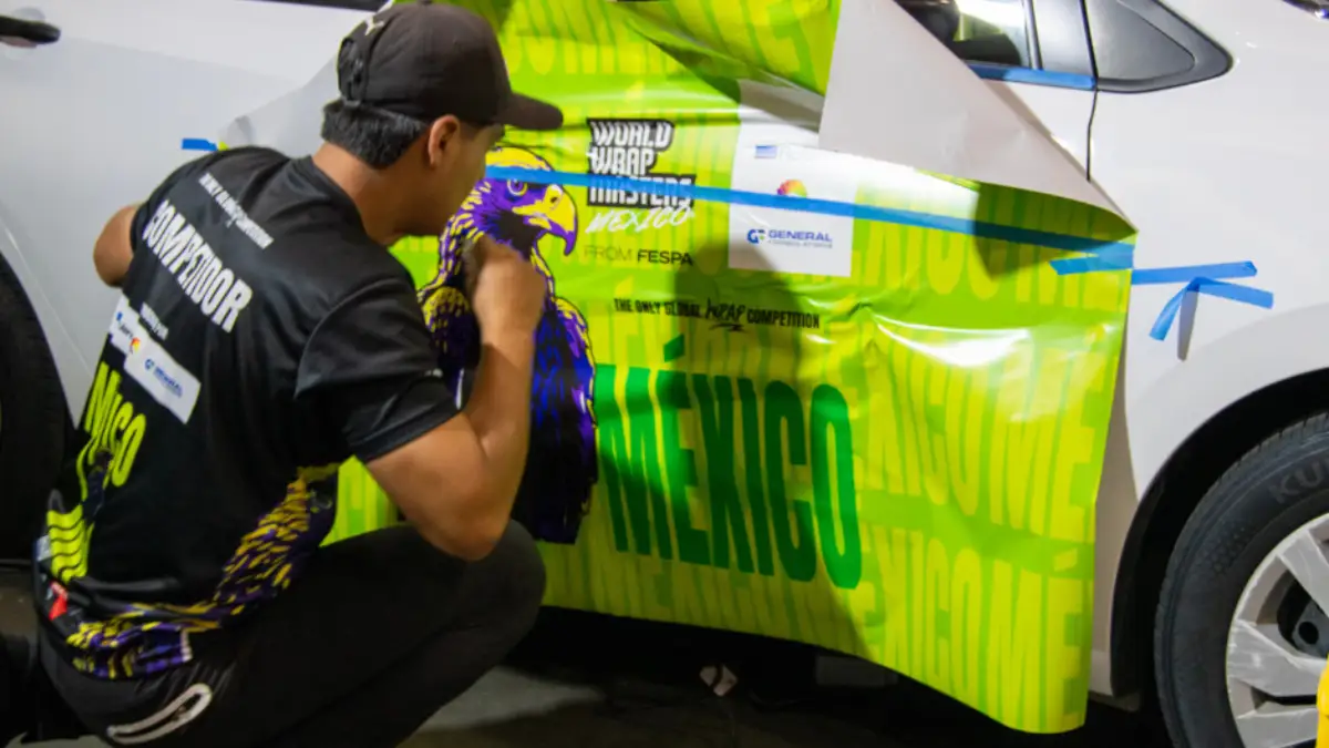 Profesional aplicando vinil de car wrapping con diseño mexicano en vehículo